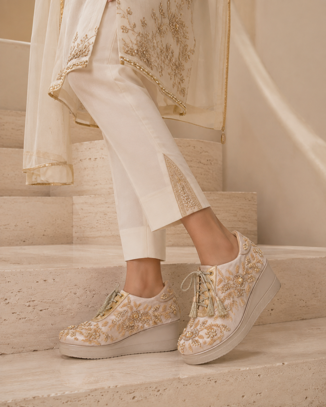 Model wearing ivory hand-embroidered statement wedges